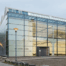 Außenansicht des Alf‑Lechner‑Museums in Neumarkt: Kubischer Bau mit silbrig‑grauer, leicht gewellter Metallfassade und flachem Satteldach